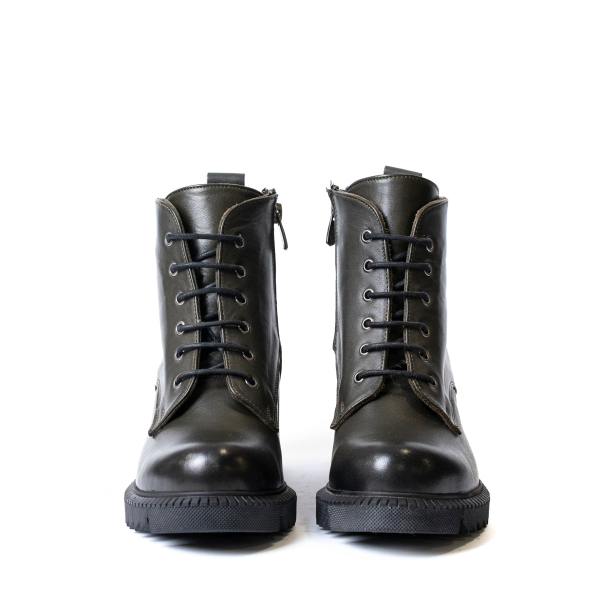 Детайл на текстурата на дамски боти от естествена кожа в маслено зелено
